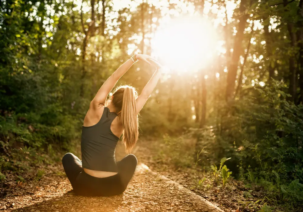 Jeune femme faisant du Yoga en forêt